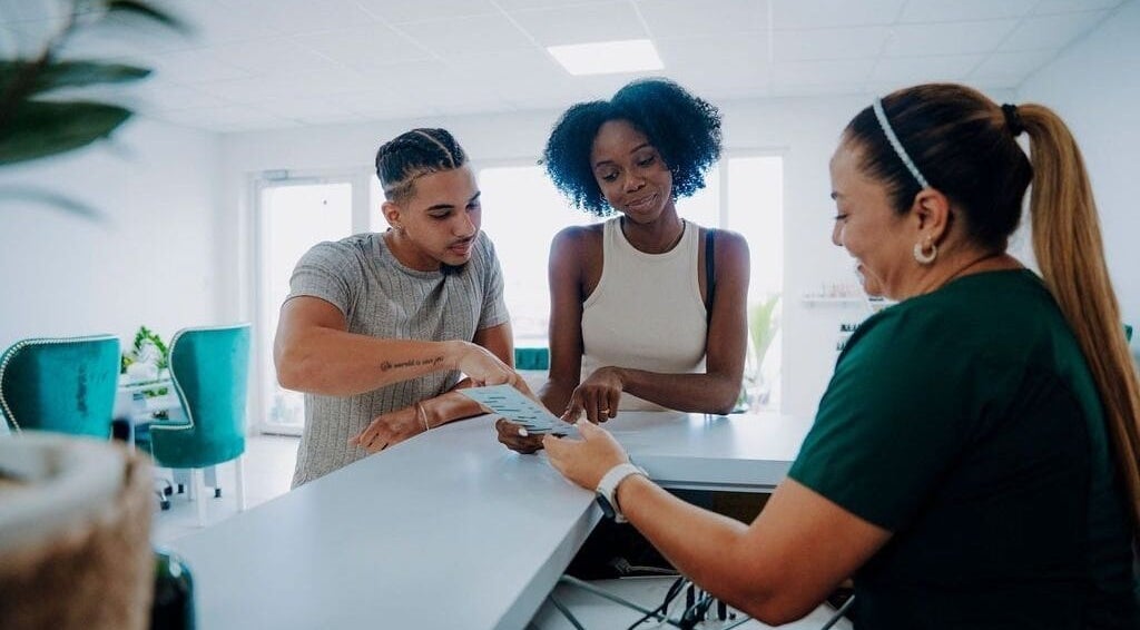 Guests discussing spa services with receptionist at Kundalini Spa Aruba, Noord, US.
