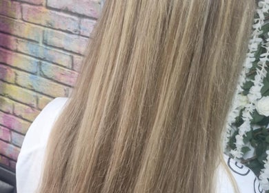 Elegant long blonde hair against a floral backdrop at Roots & Rebel, Ellesmere Port, England, GB.