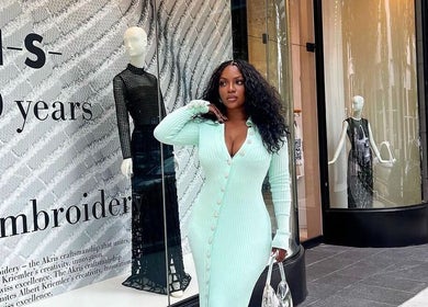 Stylish woman in mint dress outside a chic luxury hair studio in New York, New York, US.