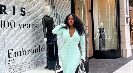 Stylish woman in mint dress outside a chic luxury hair studio in New York, New York, US.