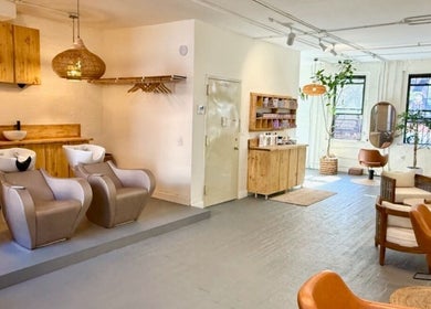Elegant interior of The Knotless Shop in New York, New York, US, showcasing stylish salon chairs and cozy decor.