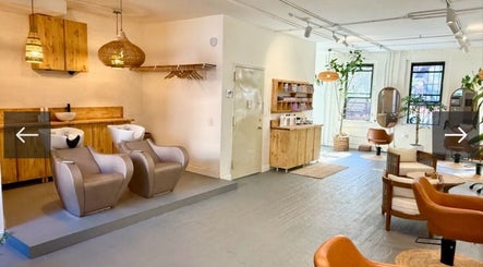Elegant interior of The Knotless Shop in New York, New York, US, showcasing stylish salon chairs and cozy decor.