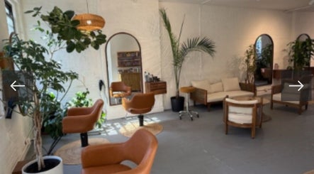 Relaxing interior of The Knotless Shop, New York, New York, US with stylish chairs and lush greenery.