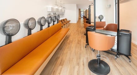Chic luxury hair studio in New York, New York, US features sleek seating and modern dryers.