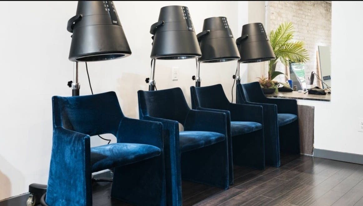 Luxurious blue velvet salon chairs with dryers at Chic Luxury Hair Studio, New York, New York, US.
