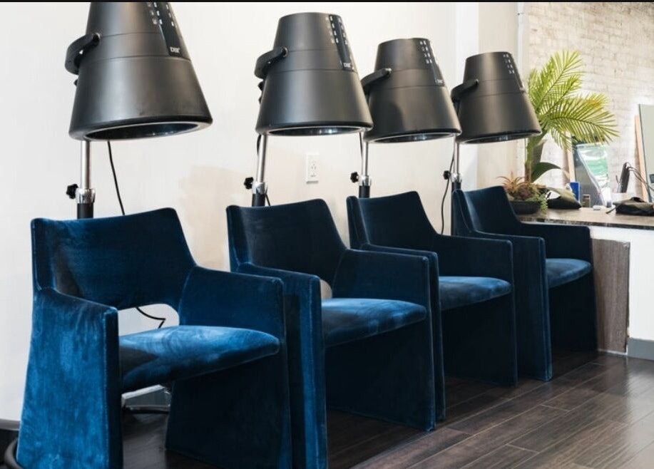 Luxurious blue velvet salon chairs with dryers at Chic Luxury Hair Studio, New York, New York, US.