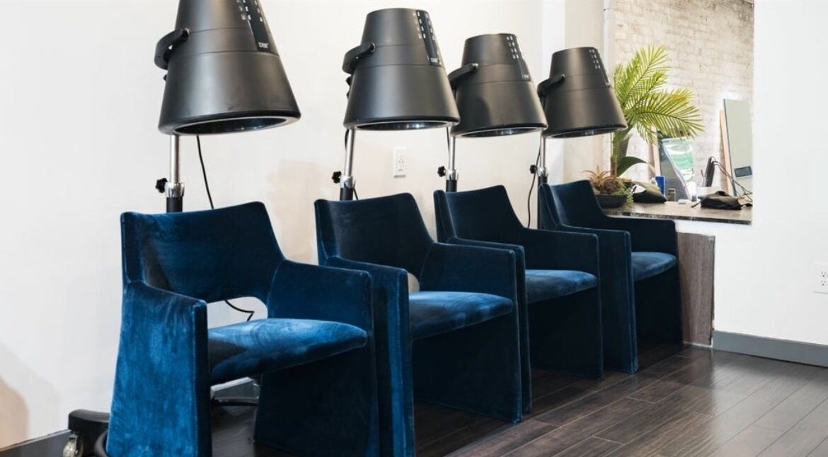 Luxurious blue velvet salon chairs with dryers at Chic Luxury Hair Studio, New York, New York, US.