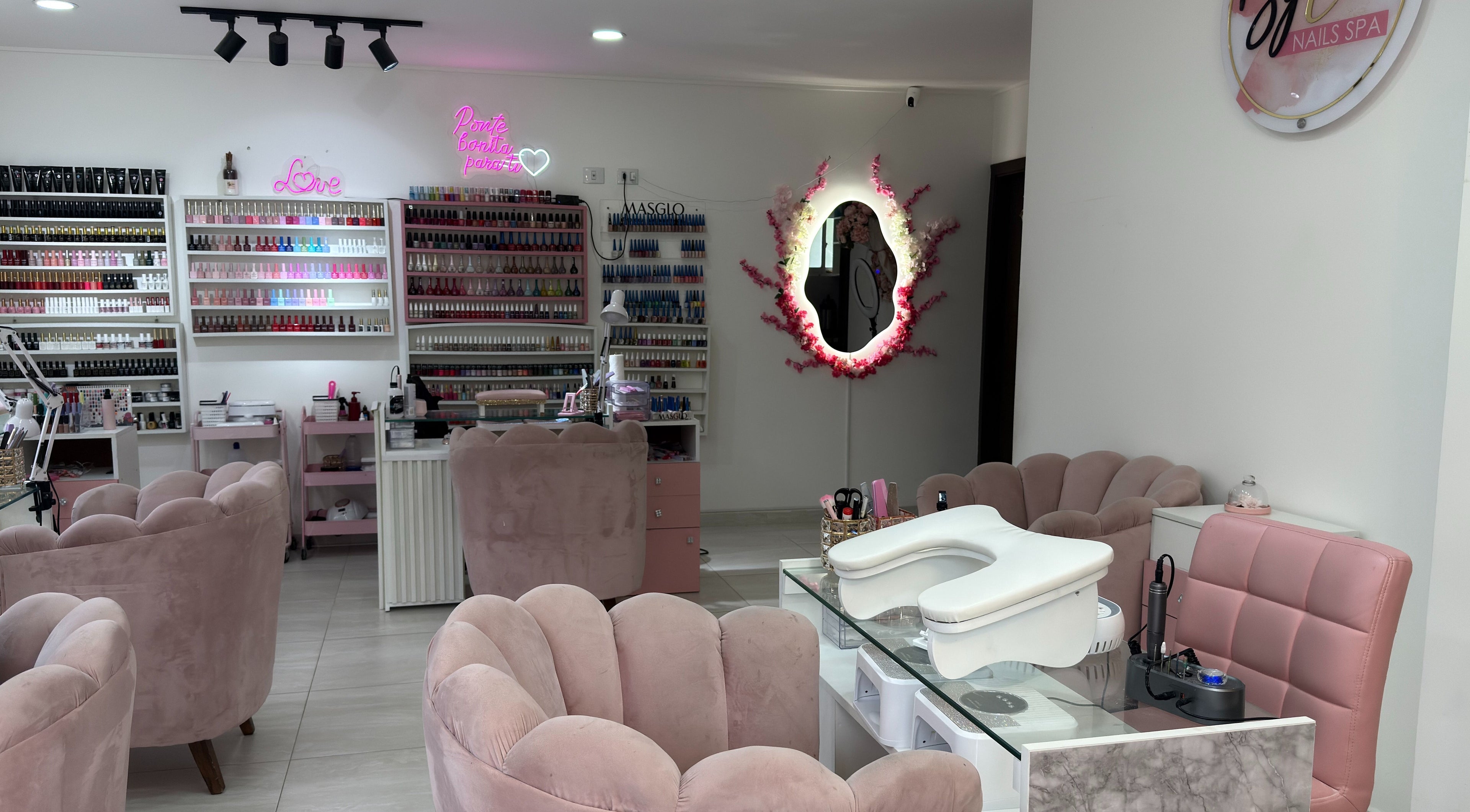 Interior acogedor de ByLove Spa, Santa Cruz De La Sierra. Sofás rosados y estantes de esmaltes.