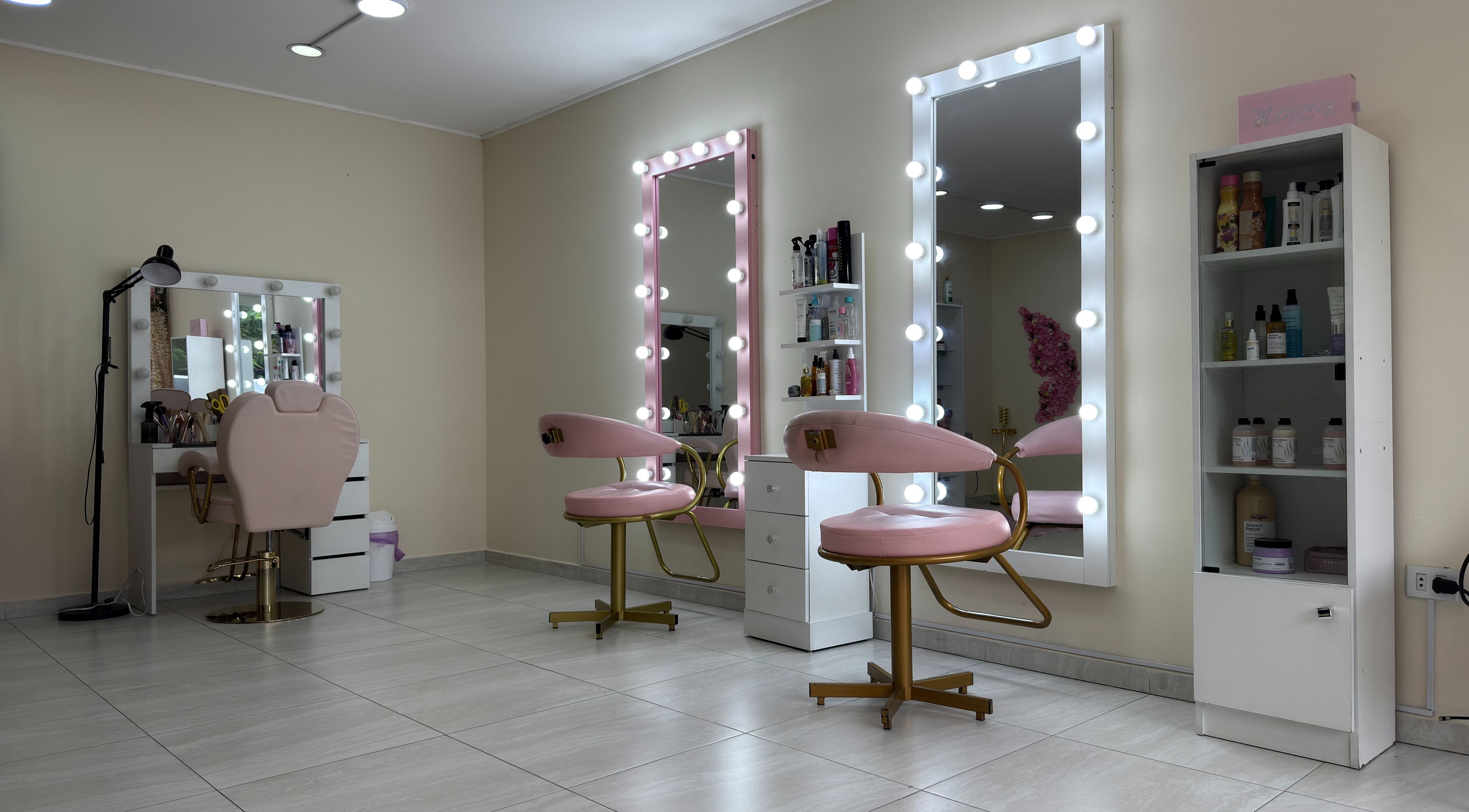 Interior elegante de ByLove Spa en Santa Cruz De La Sierra, con sillas rosas y espejos iluminados.