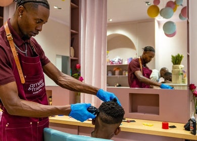 Hairstylist giving a kid's haircut at Amara and Friends kiddies Salon, Sandton, Gauteng, ZA.