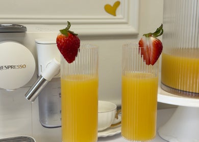 Strawberry-adorned juice glasses at Elite Spa and Beauty, Cape Town, Western Cape, ZA alongside a Nespresso machine.