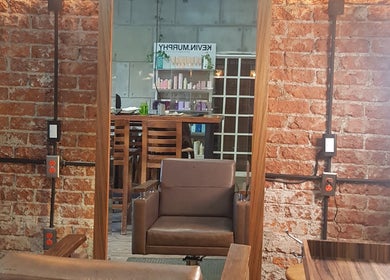 Espejo de peluquería en The Fashion Victim, Ciudad De México, MX, con silla moderna y pared de ladrillo.