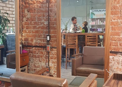 Interior acogedor de The Fashion Victim en Ciudad De México, con paredes de ladrillo y mobiliario moderno.