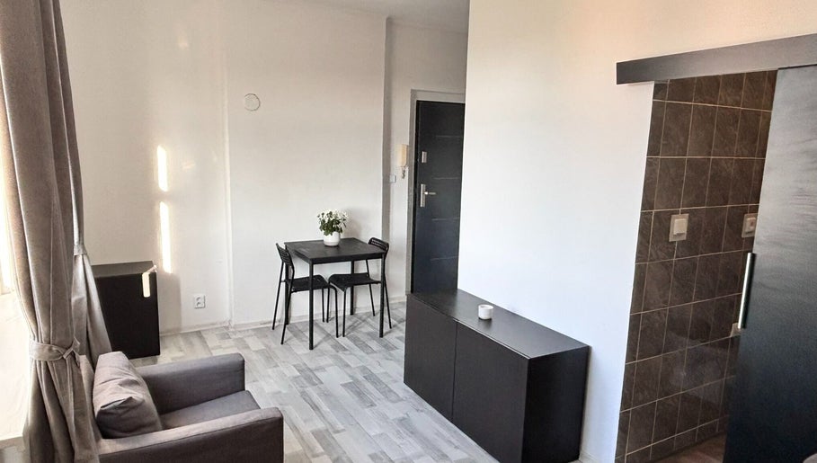 Modern cozy room at Blinkz, Hlavní Město Praha, CZ showcasing a chic gray chair and sleek table setup.