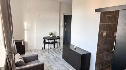 Modern cozy room at Blinkz, Hlavní Město Praha, CZ showcasing a chic gray chair and sleek table setup.