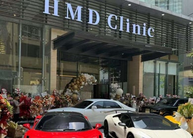 HMD Beauty Center in Kuala Lumpur with luxury cars at entrance, elegant decor.