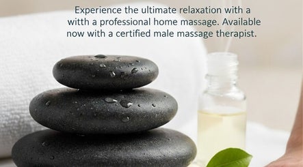 Smooth black stones beside massage oil at Massage2U, Morisset, New South Wales, AU, promoting relaxation and wellness.