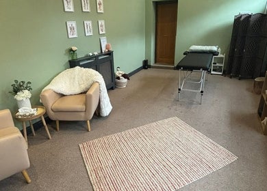 Calm therapy room at Dragonfly Counselling & Reiki, Hebburn, England, with chairs and a massage table.
