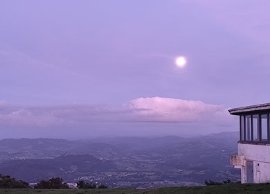 Apus impresionant la Beauty Santander, ES, cu un cer violet și o clădire panoramică.