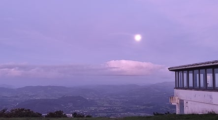Apus impresionant la Beauty Santander, ES, cu un cer violet și o clădire panoramică.