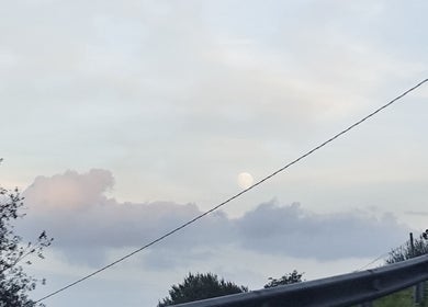 Peisaj de apus peste Beauty în Santander, ES, cu nori și lună pe cer.