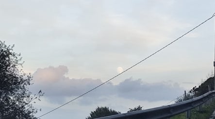 Peisaj de apus peste Beauty în Santander, ES, cu nori și lună pe cer.