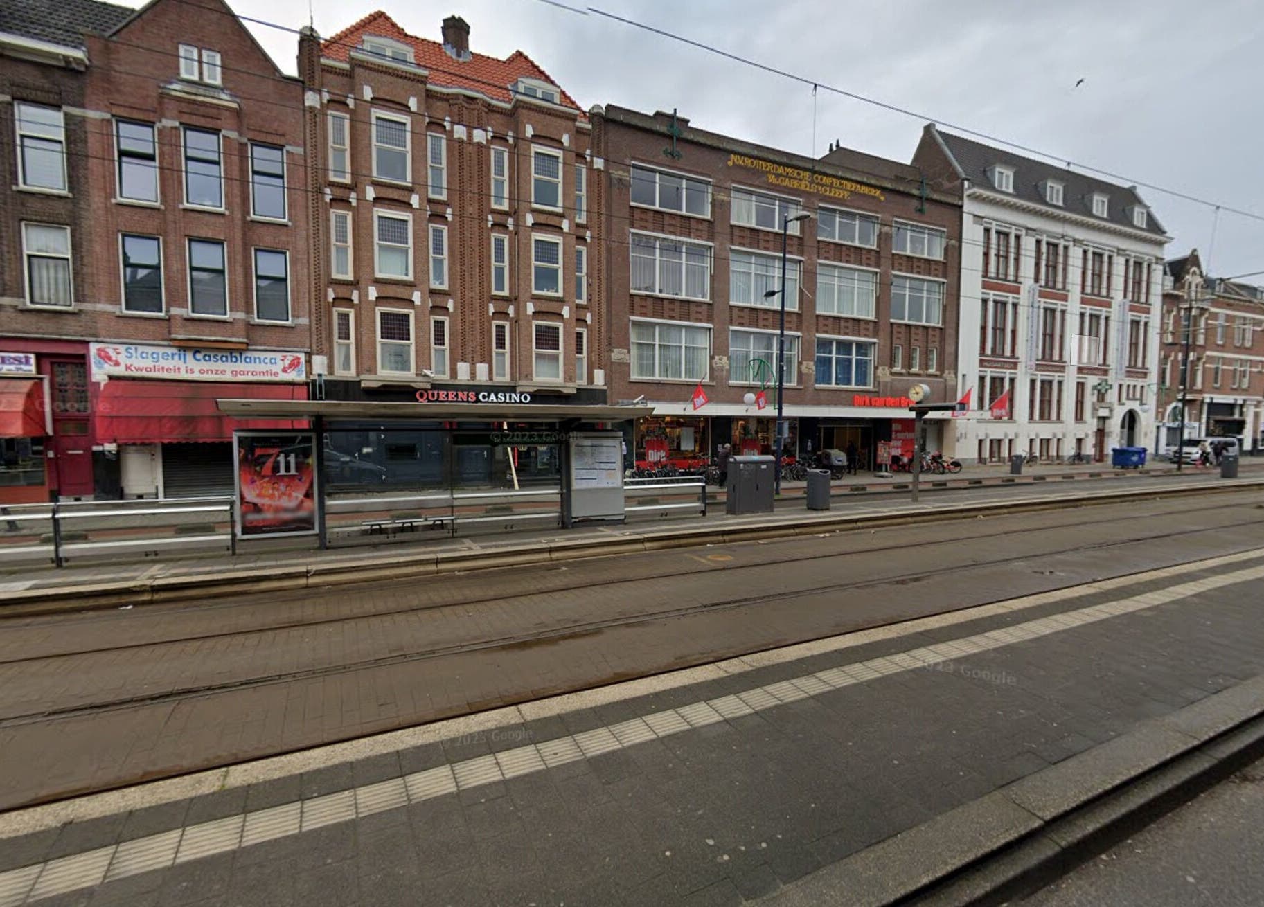 Street view of CarlosKapperRotterdamWest's location in Rotterdam, Zuid-holland, NL with tram tracks and storefronts.