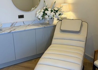 Relaxing lounge chair at Peak Wellness Health and Medispa, Dronfield, England, GB, near elegant countertop and mirror.