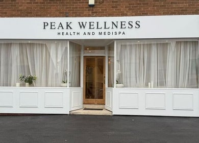 Front view of Peak Wellness Health and Medispa in Dronfield, England, GB with white decor and glass windows.