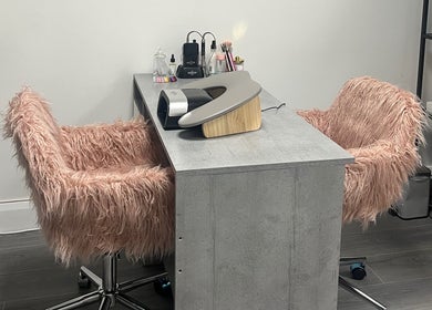 Elegant nail station at The Nail Nest by Shannen in Limerick, County Limerick, IE with plush pink chairs.