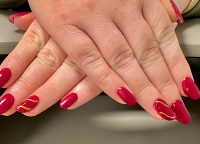 Red manicured nails with gold accents at The Nail Nest by Shannen, Limerick, County Limerick, IE.