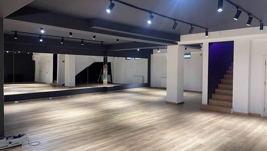 Spacious interior of Xnine Dance Studio Pilates in T'bilisi, Tbilisi, GE with mirrors and wooden flooring.