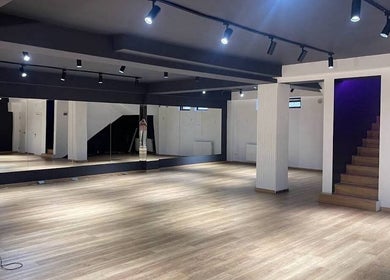 Spacious interior of Xnine Dance Studio Pilates in T'bilisi, Tbilisi, GE with mirrors and wooden flooring.