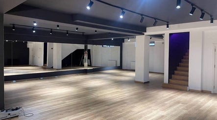 Spacious interior of Xnine Dance Studio Pilates in T'bilisi, Tbilisi, GE with mirrors and wooden flooring.