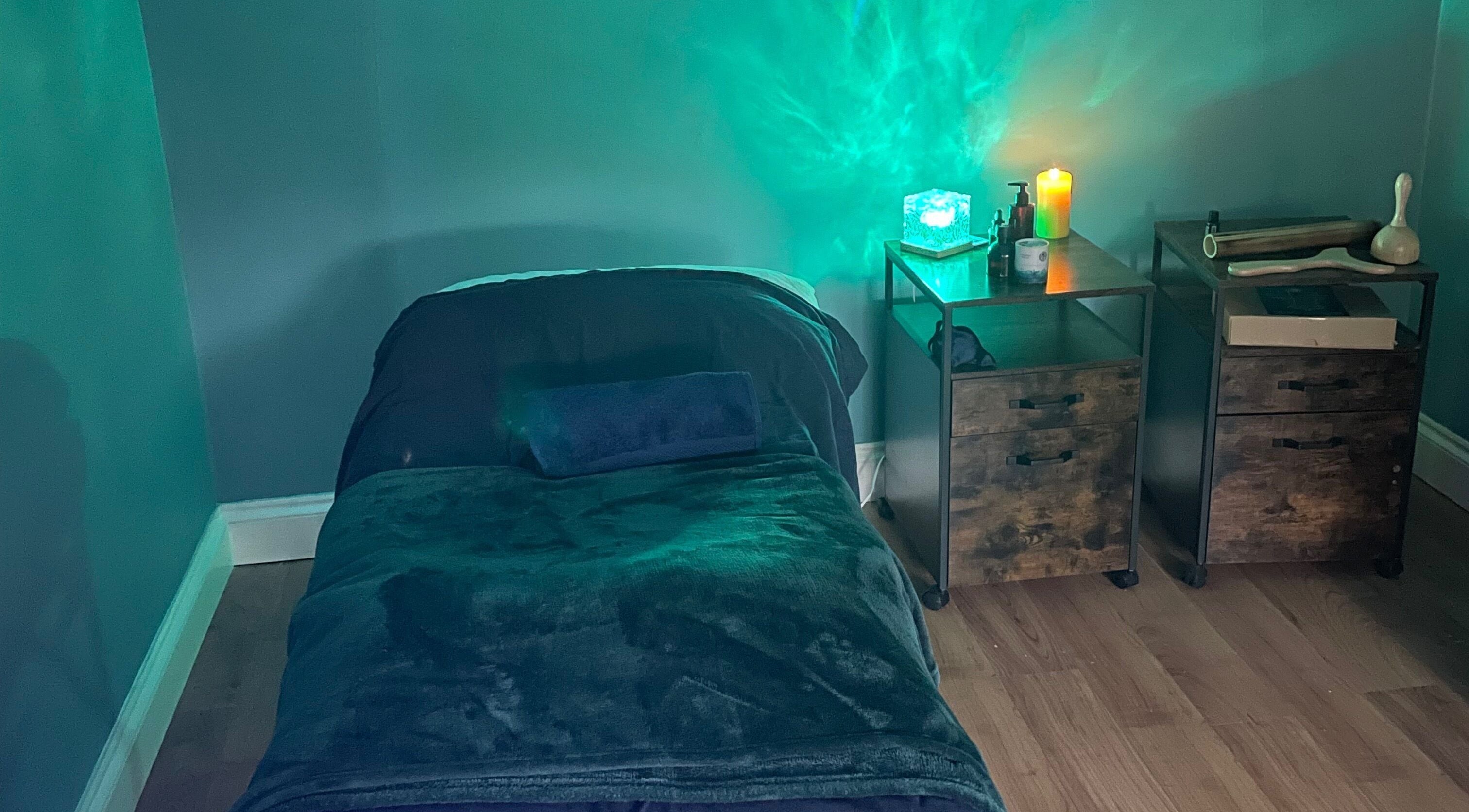 Tranquil massage room at Holistic Reflexology & Massage, Brentwood, England, GB. Soft lighting and relaxation bed.