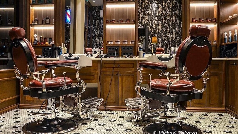 Κομψά καθίσματα κουρείου στο Ferdinandos Barbershop, Ιωάννινα, GR με καλαίσθητη διακόσμηση.