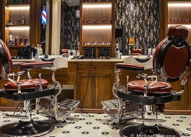 Κομψά καθίσματα κουρείου στο Ferdinandos Barbershop, Ιωάννινα, GR με καλαίσθητη διακόσμηση.