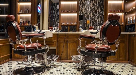 Κομψά καθίσματα κουρείου στο Ferdinandos Barbershop, Ιωάννινα, GR με καλαίσθητη διακόσμηση.