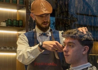 Κουρέας στο Ferdinandos Barbershop, Ιωάννινα, GR δίνει κούρεμα με προσοχή στη λεπτομέρεια.