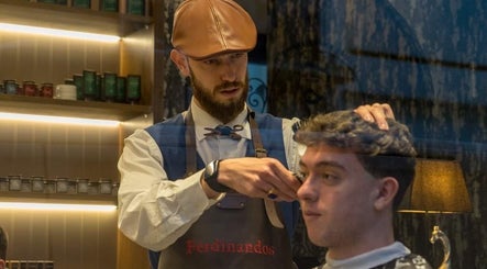 Κουρέας στο Ferdinandos Barbershop, Ιωάννινα, GR δίνει κούρεμα με προσοχή στη λεπτομέρεια.