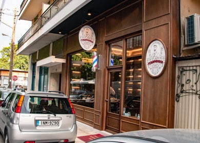 Εξωτερική όψη του Ferdinandos Barbershop στην Ιωάννινα, GR με σύγχρονη πρόσοψη και το λογότυπο.