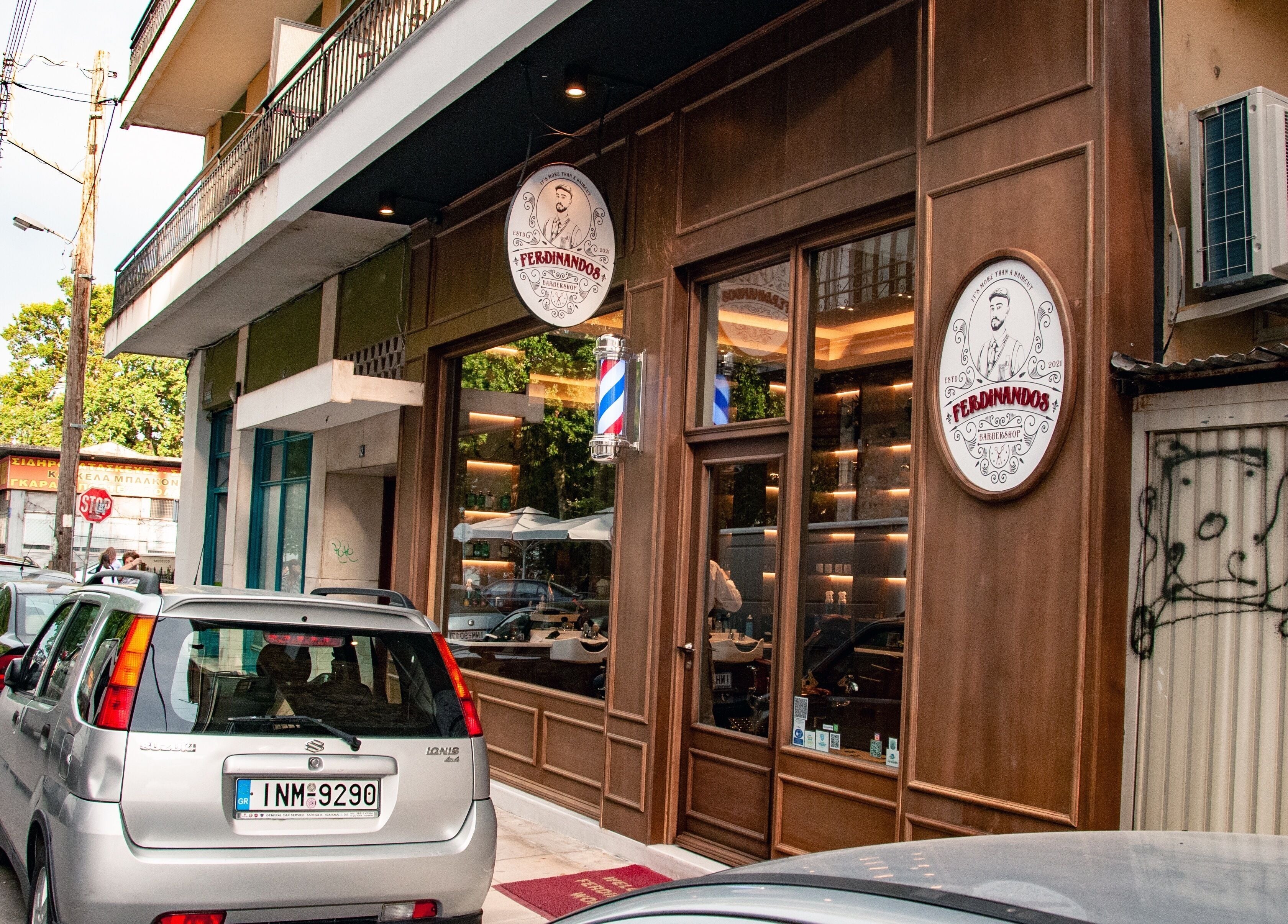 Εξωτερική όψη του Ferdinandos Barbershop στην Ιωάννινα, GR, με κομψή ξύλινη επένδυση και πινακίδα.