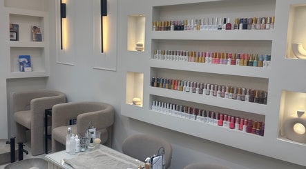 Elegant beauty lounge at Reset Beauty, London, England, GB featuring plush chairs and vibrant nail polish display.