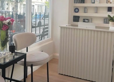 Reception area at Reset Beauty, London, England, GB, featuring elegant seating and floral decor.