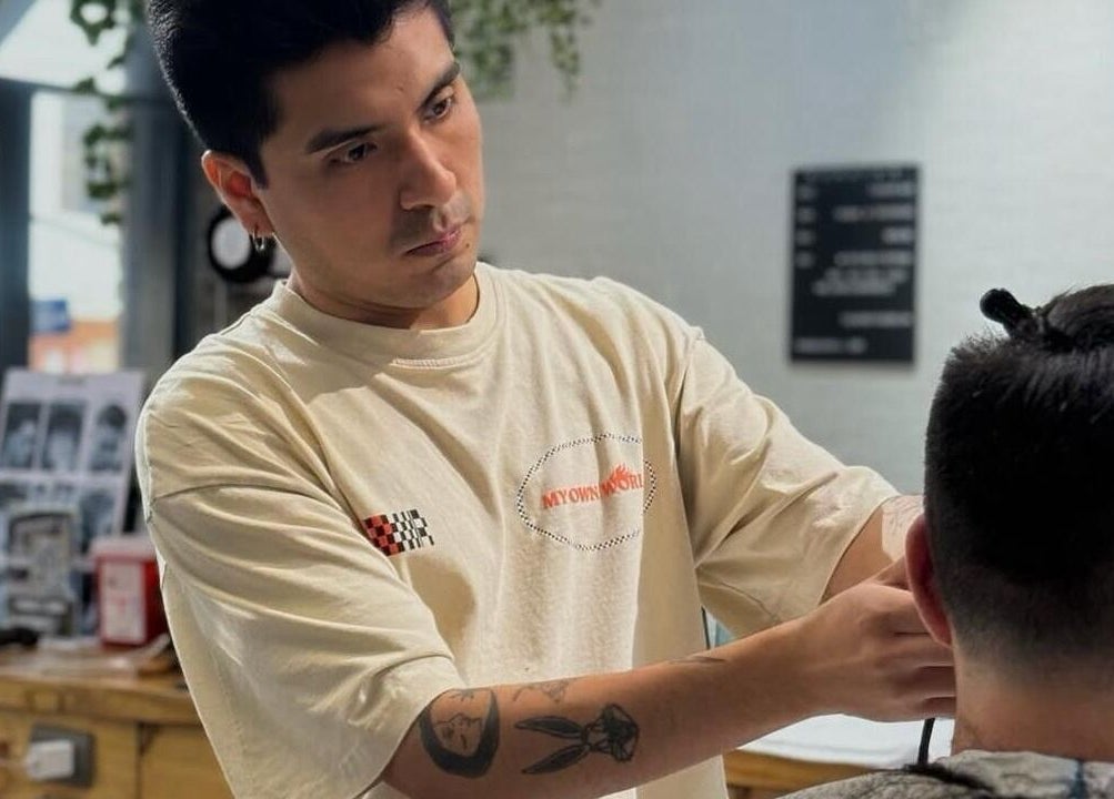 Barbero concentrado trabajando en corte de cabello en Groomed Hair, Miraflores, Provincia De Lima, PE.