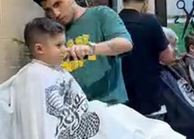 Niño recibiendo corte de cabello en Groomed Hair, Miraflores, Provincia De Lima, PE. Ambiente profesional y moderno.