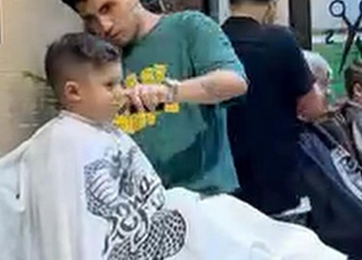 Niño recibiendo corte de cabello en Groomed Hair, Miraflores, Provincia De Lima, PE. Ambiente profesional y moderno.