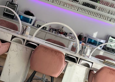 Λεπτομέρειες σαλονιού Toobi beauty nails & more, Νίκαια, GR με ροζ βελούδινες καρέκλες και στιλάτο ντεκόρ.