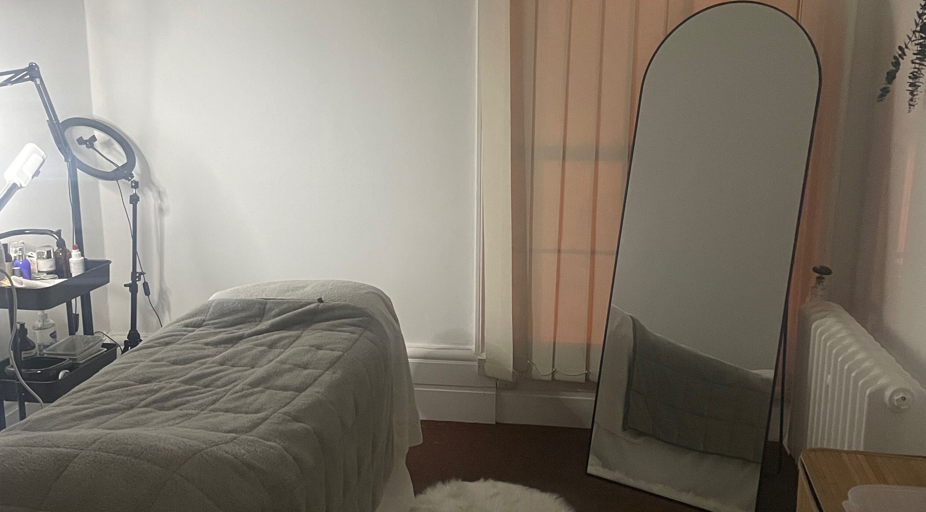 Cozy treatment room at Skincare Studio Uk, Saffron Walden, England, GB with a massage table and mirror.