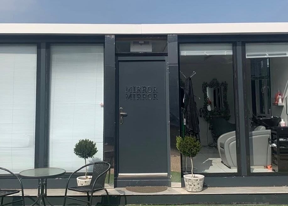 Modern storefront of Ash Fern Tattoo in Romford, England, GB, with a stylish salon and greenery.